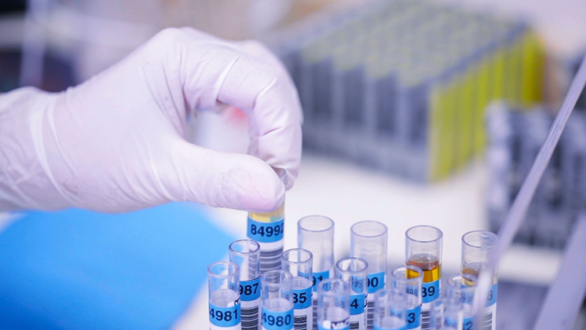 Scientist Handling Test Tubes with Barcode